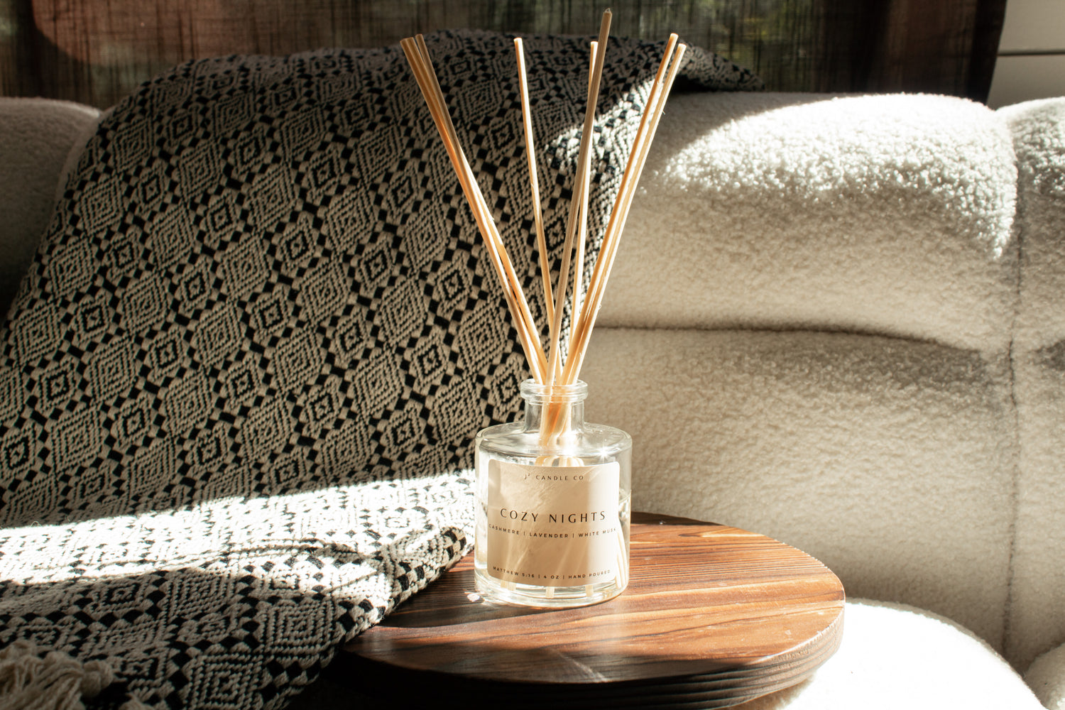 Diffuser with reeds on a wooden table in a living room setting