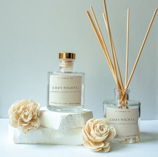 Cozy Nights candle and diffuser set with decorative flowers on a light background