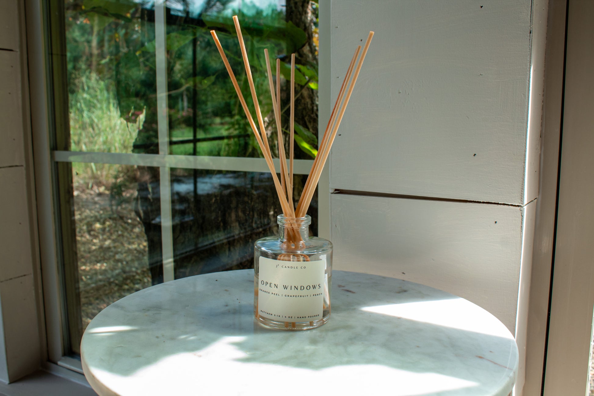 Diffuser with wooden sticks on a table near a window