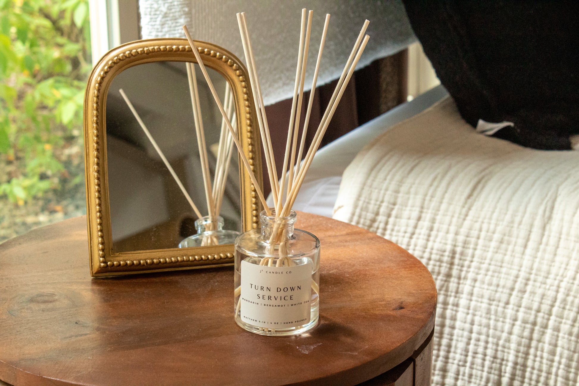 Reed diffuser with decorative frame on a wooden table