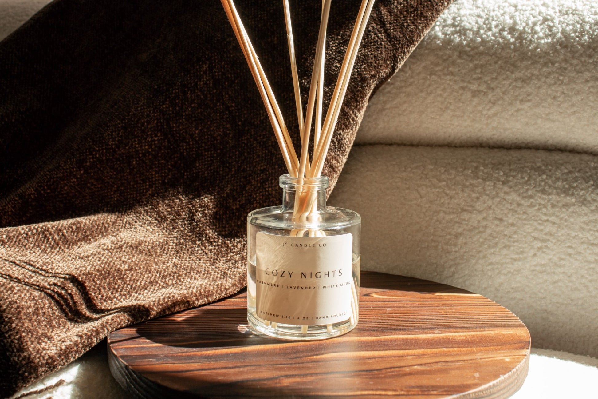 Diffuser with wooden sticks on a wooden coaster with a blurred background